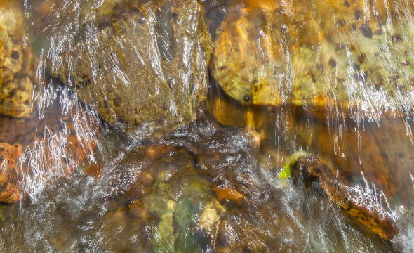 Natural background, the stones at the bottom of the creek. Clean stream.