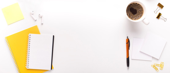 Morning coffee on workplace with yellow stationery and notepad