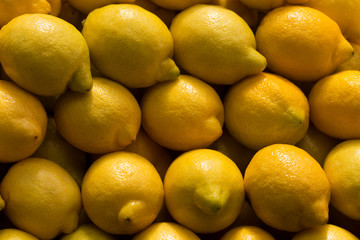 A pile of lemons at the vegetable market. Macro background of citruses.