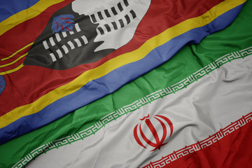 waving colorful flag of iran and national flag of swaziland.
