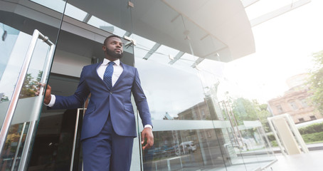 Young african job seeker leaving building after interview