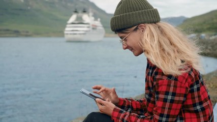 Young woman sits in port watch cruise ship leave