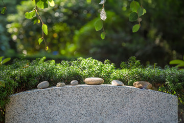 Steine auf einem Grabstein in einem Park
