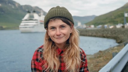 Young woman sits in port watch cruise ship leave