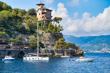 Portofino, Italy - AUGUST 15, 2019: Beautiful bay with yachts, cliff house, beaches, mountain views / popular resort in Europe