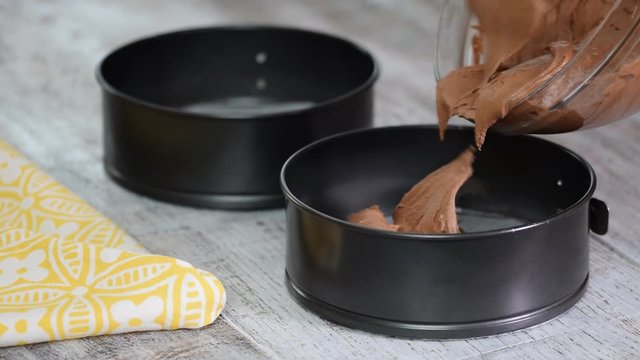Pouring cake mix into baking tin, springform . Making chocolate Cake.