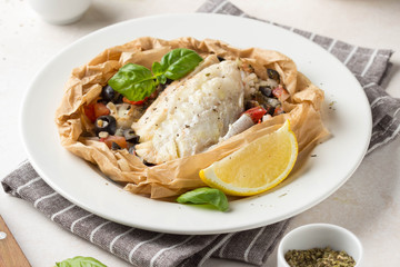 Fillet of white fish (Pollock, cod, sea bass, Dorada) with olives, tomatoes and lemon, baked in...