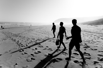 Fototapeta na wymiar silhouette of three people walking onto a beach