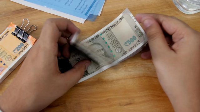 Accountant counting rupees 500 Indian currency notes . 