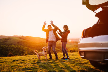 Father and daughter playing with dog at hill camping
