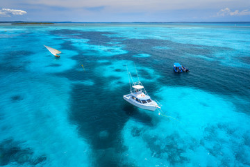Aerial view of the yachts, fishing boats in transparent blue water at sunny day in summer. Top view...