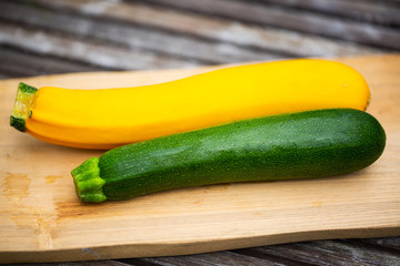 gelbe und grüne Zucchini auf Holzbrett