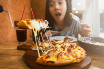 young girl excited for eating Very cheesy pizza slice