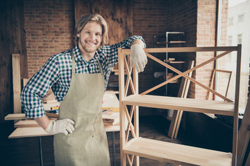 Portrait of his he nice handsome blond cheerful cheery content guy woodworker wearing checked shirt uniform well done ready order at industrial brick loft style interior