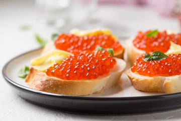Naklejka na ściany i meble Red caviar on baguette toast with butter, appetizer for wine, champagne. Holiday, new year, Christmas, buffet. Delicious canape, food