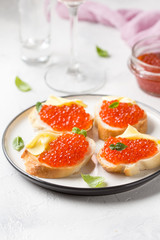 Naklejka na ściany i meble Red caviar on baguette toast with butter, appetizer for wine, champagne. Holiday, new year, Christmas, buffet. Delicious canape, food