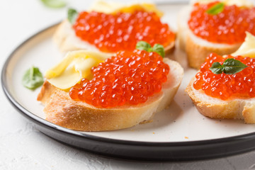 Red caviar on baguette toast with butter, appetizer for wine, champagne. Holiday, new year, Christmas, buffet. Delicious canape, food
