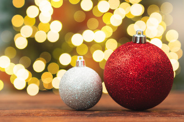 Christmas balls on a wooden table against blurred shiny bokeh background