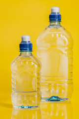 Pure water in plastic bottle on bright yellow background