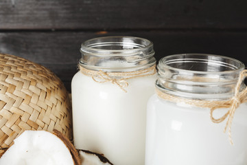 Coconut milk glass jar close up on wooden background