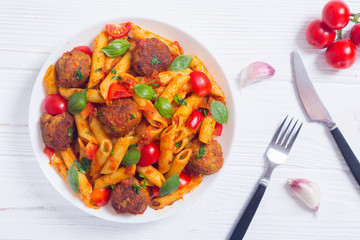 Italian penne pasta with meatballs and tomatoes