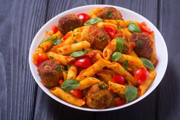 Italian penne pasta with meatballs and tomatoes