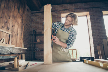 Low angle view of his he nice attractive handsome blond serious focused hard-working guy measuring boards at industrial brick loft style interior indoors workplace