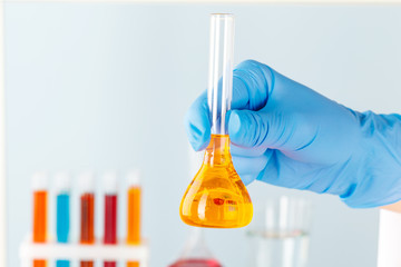 Manipulations with laboratory glass chemical containers on table