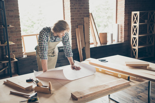 Portrait of his he nice attractive handsome blond focused guy artisan builder reading drafts creating projects at industrial brick loft style interior indoors workplace studio