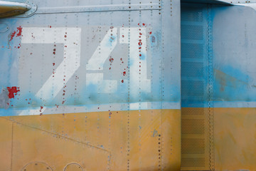 Number on a military aircraft fuselage. Texture. Old camouflage surface with exfoliated paint and rivets on a military aircraft.