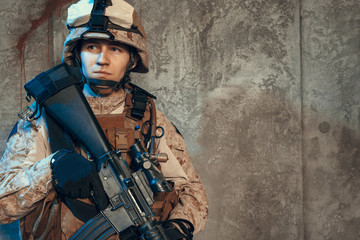 fully equipped army soldier in camo uniform and helmet, armed with pistol and assault service rifle