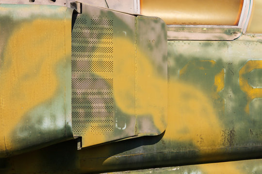 Detail of an old camouflage surface with exfoliated paint on a military aircraft. Fragment of a fuselage of an old jet fighter