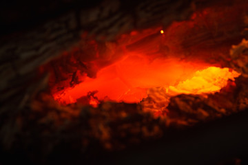 Fototapeta premium Burning coal closeup. Abstract background red hot burning fire in the oven macro close up of coal. Shallow depth of field (DOF)