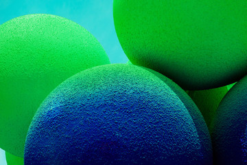 Green and blue balls balloons on cloud sky background. Macro close up image. Vivid holiday poster with copy space. Sunny happy day concept