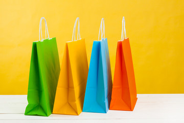 Paper shopping bags on bright yellow background