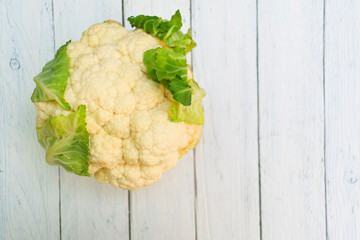 Organic cauliflower isolated on a white wood background. Copy space.