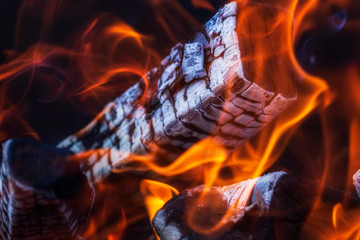 Fototapeta premium Burning firewood. Fire and firewood fever. Coal in the hearth. Concept - heat and coziness of the hearth, fire. 