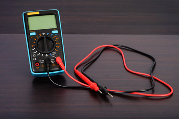 Digital multimeter with probes on a white background.