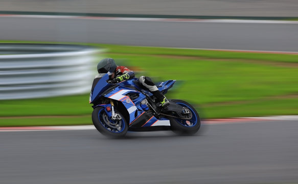 Racing bike rider leaning into a fast corner at high speed