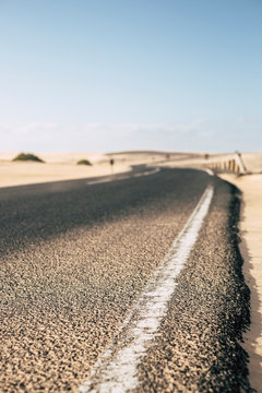 Ground point o view of asphalt long road in the outdoor desert nature - concept of travel and adventure - transportation image in african torpical place - blue sky in background
