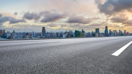 Empty highway and city skyline with buildings at sunset in Shanghai,China.