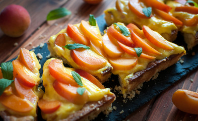 Close-up of homemade apricot tart with pastry cream and fresh mint