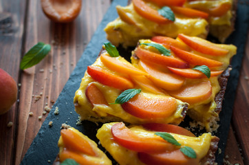 Close-up of homemade apricot tart with pastry cream and fresh mint