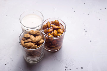 Three glasses with almonds at different stages of making milk from nuts