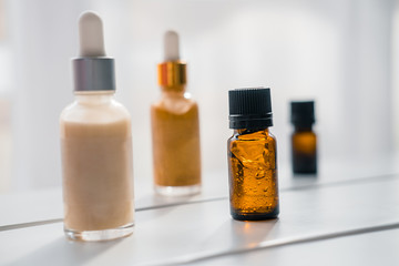 Glass bottles with dropper pipettes. Luminous and luxury gold and white liquid highlighter drops. Beauty blogger essentials. Minimalism package, branding mockup. Direct sun light