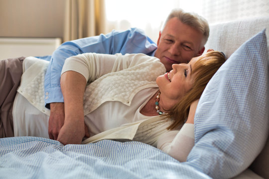 Sweet senior couple cuddling in bed