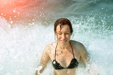 Obraz premium Beautiful young woman. In the spray of the sea wave.