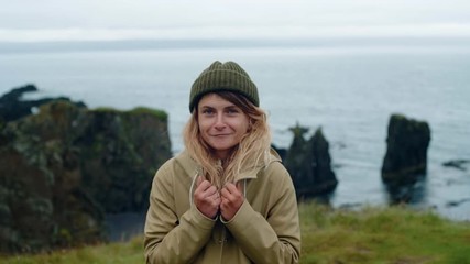 Young woman warms hands with breath in norway