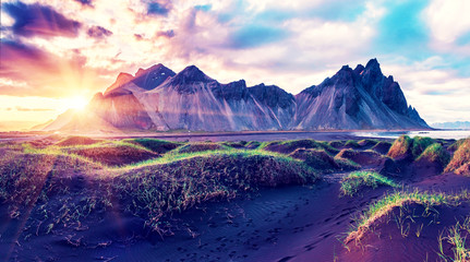 Scenic landscape with most beautiful mountains Vestrahorn on the Stokksnes peninsula and cozy lagoon with green grass on the sand dunes at sunset in Iceland. Exotic countries. Amazing places. © anko_ter