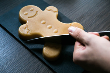 cutting off a leg of delicious seasonal fudge gingerbread man 